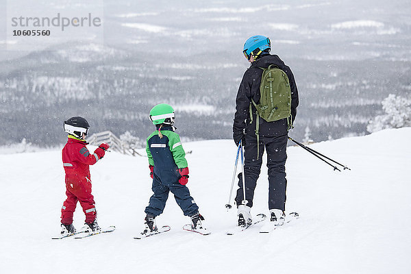 Vater mit Kindern beim Skifahren