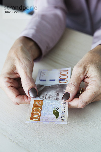 Frau hält schwedische Kronen-Banknote