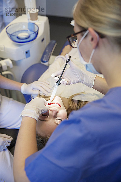 Junges Mädchen mit Zahnfüllung in der Zahnarztpraxis