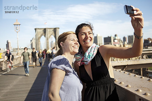 Zwei Touristinnen machen ein Selfie auf der Brooklyn Bridge