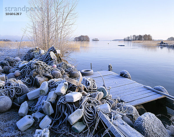 Frost auf Seilen und Bojen an einer Strandpromenade.