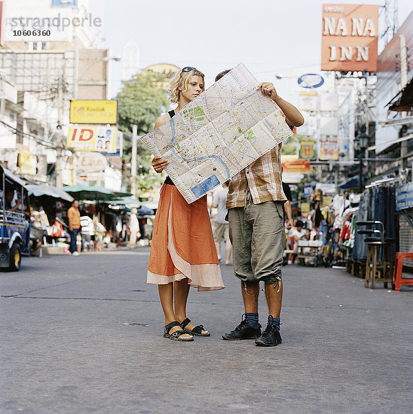 Ein Paar schaut auf eine Landkarte  Thailand.