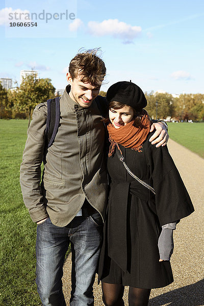 Ein junges Paar geht im Hyde Park in London spazieren.