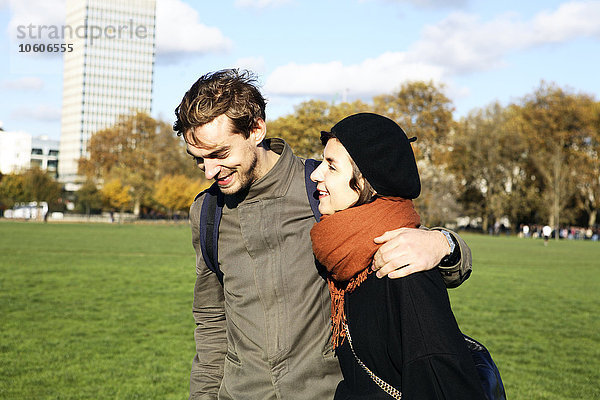 Ein junges Paar geht im Hyde Park in London spazieren.