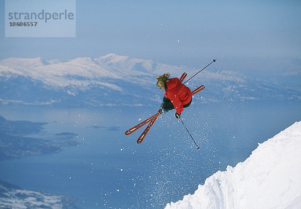 Eine Frau springt beim Skifahren.