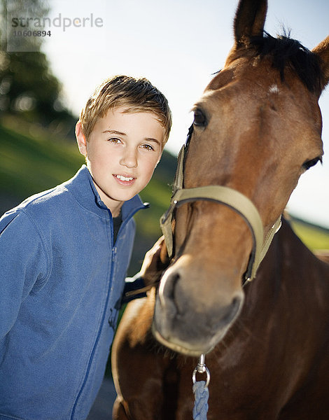 Ein Junge kümmert sich um ein Pferd  Schweden.