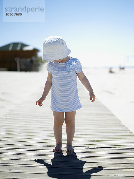 Ein kleines Mädchen geht am Strand spazieren  Portugal.