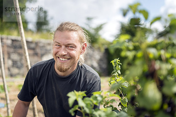 Lächelnder Mann bei der Arbeit im Garten