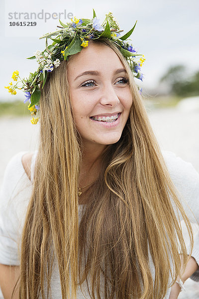 Lächelndes jugendliches Mädchen mit Blumenkranz