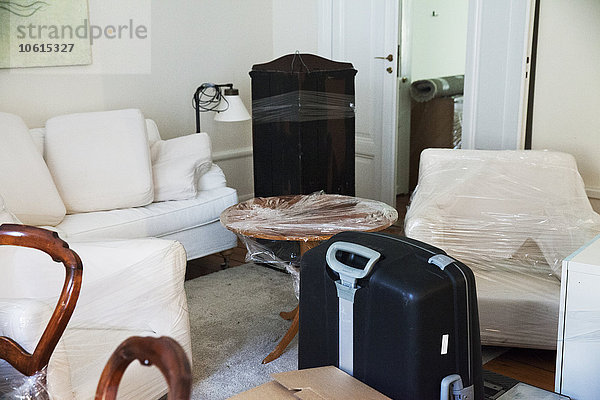 Verpacken von Möbeln und Umzugskartons im Wohnzimmer