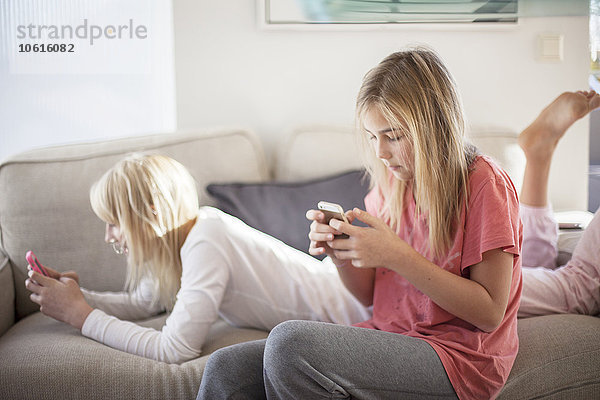 Teenager-Mädchen auf dem Sofa  die Handys benutzen