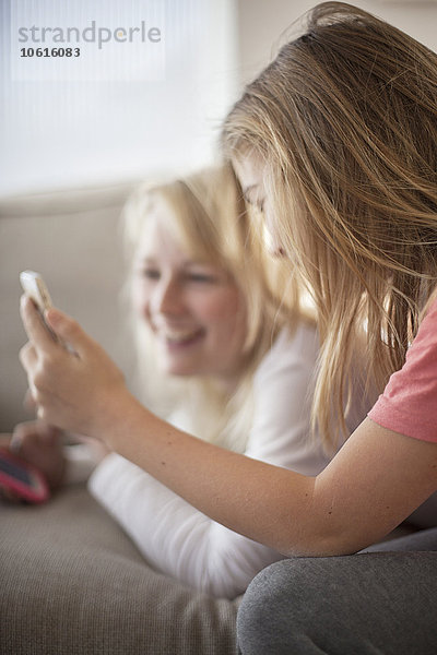 Teenager-Mädchen auf dem Sofa  die Handys benutzen