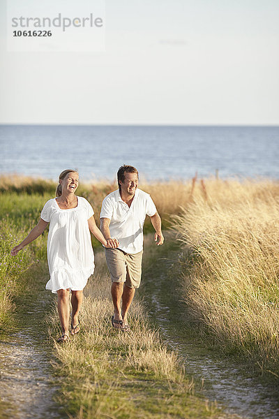 Glückliches Paar beim Spaziergang am Meer