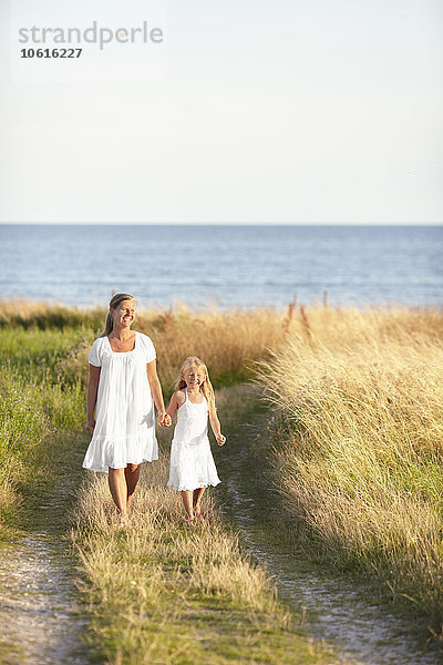 Mutter mit Tochter bei einem Spaziergang am Meer