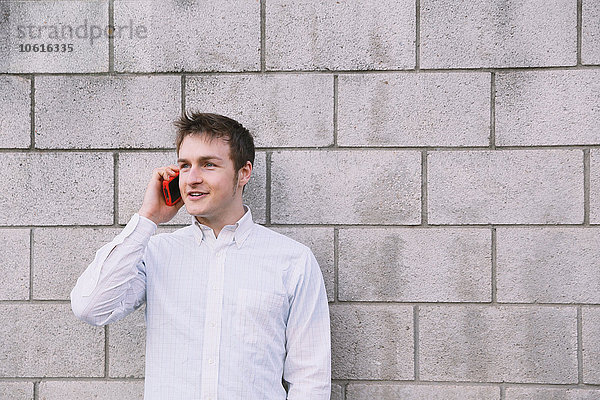 Porträt eines jungen kaukasischen Mannes am Telefon