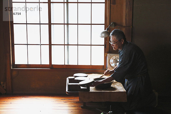 Japanischer Lackkunsthandwerker bei der Arbeit im Atelier