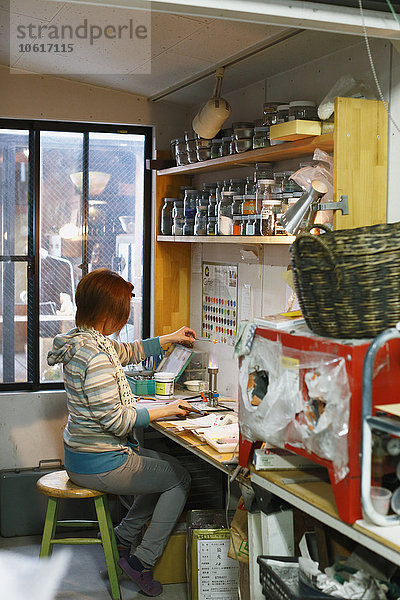 Japanische Glaskünstlerin bei der Arbeit im Atelier