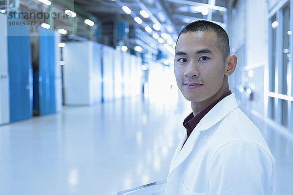 Porträt eines selbstbewussten Wissenschaftlers im Fabrikkorridor