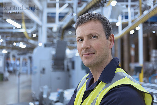 Nahaufnahme des Porträts eines selbstbewussten Arbeiters in der Fabrik