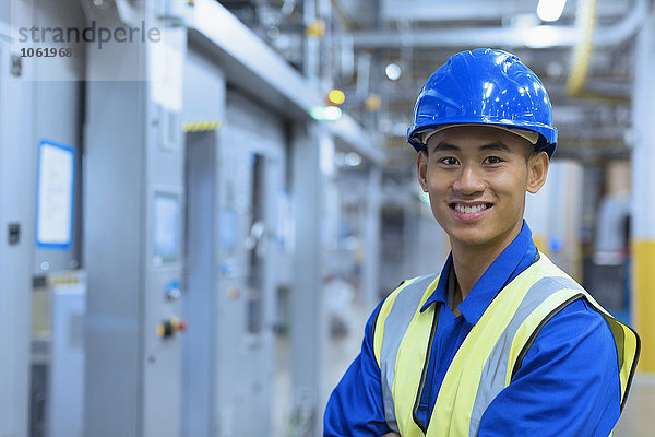 Porträt eines lächelnden Arbeiters mit Helm in der Fabrik