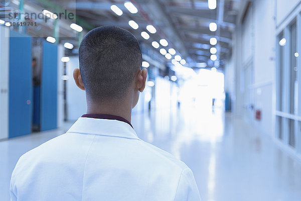 Wissenschaftler blickt den langen Fabrikkorridor hinunter