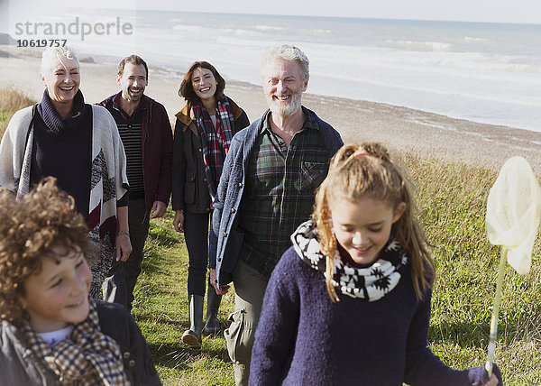 Mehrgenerationen-Familienwanderung auf einem grasbewachsenen Strandweg