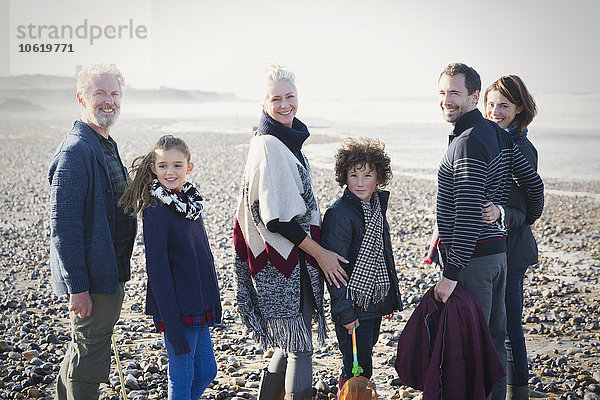 Portrait lächelnde Mehrgenerationen-Familie am sonnigen Strand