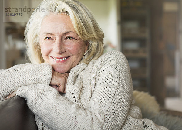Lächelnde Seniorin im Pullover schaut weg