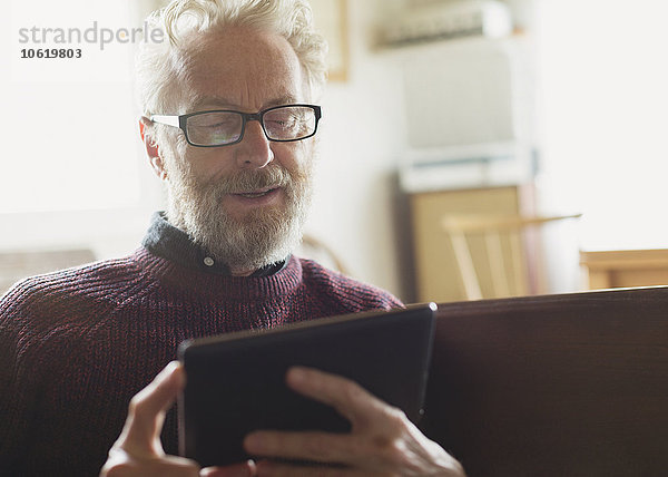 Senior-Mann mit Brille und digitalem Tablett