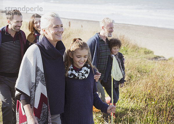 Lächelndes Mehrgenerationen-Familienwandern im Strandgras