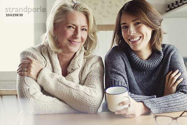 Portrait lächelnde Mutter und Tochter in Pullovern beim Kaffeetrinken in der Küche