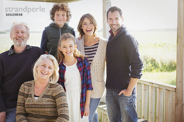 Portrait lächelnde Mehrgenerationen-Familie auf sonniger Veranda