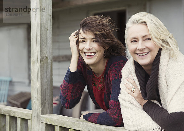 Portrait lächelnde Mutter und Tochter auf windiger Veranda