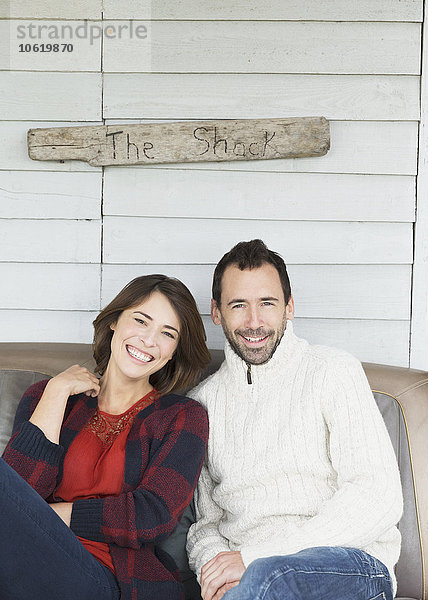 Portrait lächelndes Paar auf der Veranda unter dem Schild The Shack .