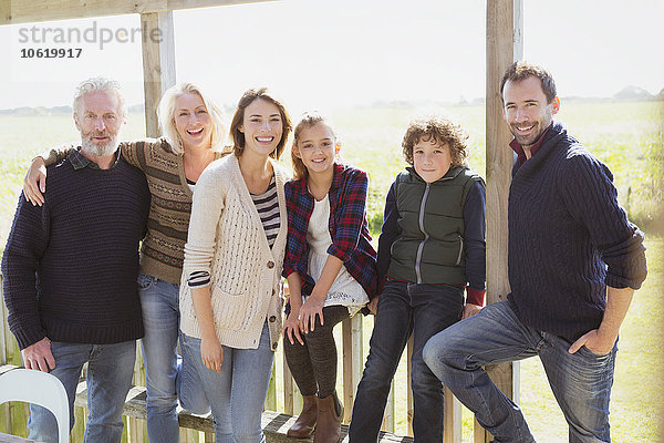 Portrait lächelnde Mehrgenerationen-Familie auf sonniger Veranda