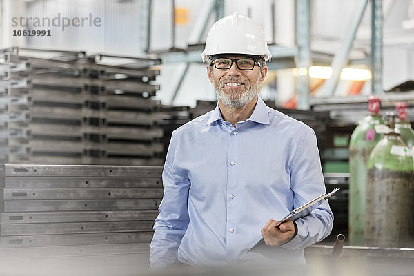 Portraitsicherer Ingenieur mit Zwischenablage im Werk