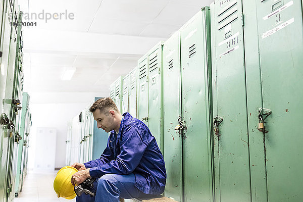 Arbeiter mit Helm im Umkleideraum