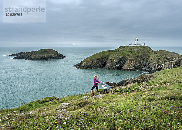 UK  Pembrokeshire  Strumble head  Reife Frau  die den Küstenpfad läuft