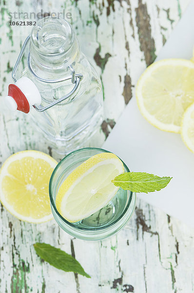 Zitronenscheibe und Minze in Wasserglas  Flasche