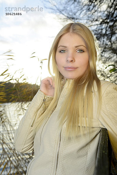 Porträt einer jungen blonden Frau vor einem See