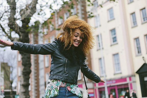 Irland  Dublin  lächelnde Frau mit Afro-Balancing