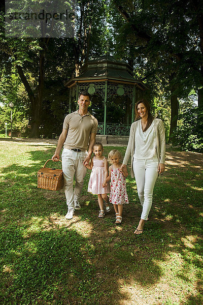 Glückliche Familie im Park  Eltern mit Picknickkorb