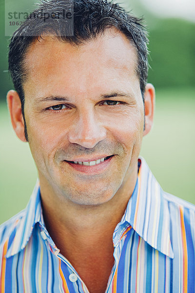 Porträt eines lächelnden Mannes mit gestreiftem Hemd