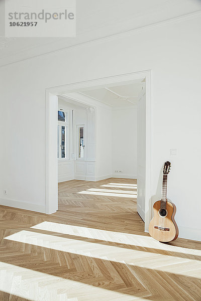 Gitarre an die Wand gelehnt  leerer Raum