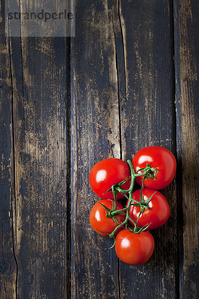 Bund Tomaten auf dunklem Holz