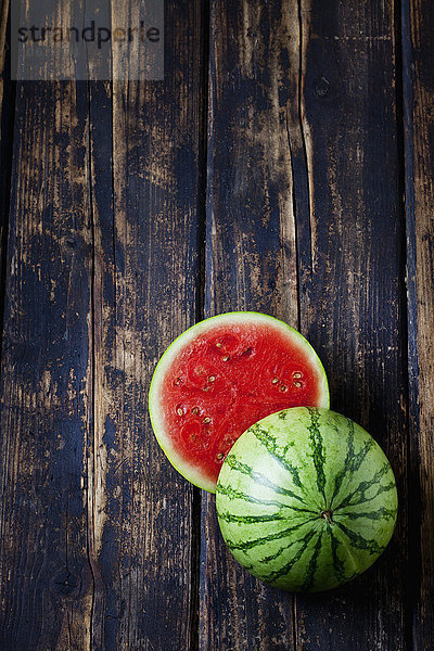 Geschnittene Mini-Wassermelone auf dunklem Holz