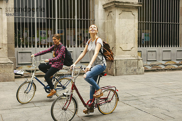 Spanien  Barcelona  zwei junge Frauen auf dem Fahrrad in der Stadt