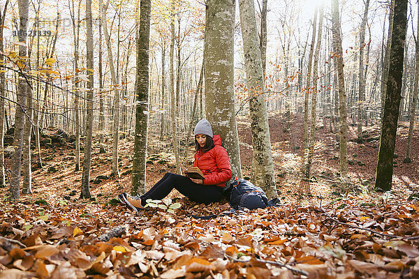 Spanien  Katalonien  Girona  Wanderin im Wald sitzend Lesebuch
