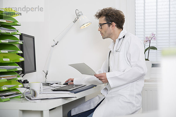 Arzt am Schreibtisch bei der Arbeit am Computer