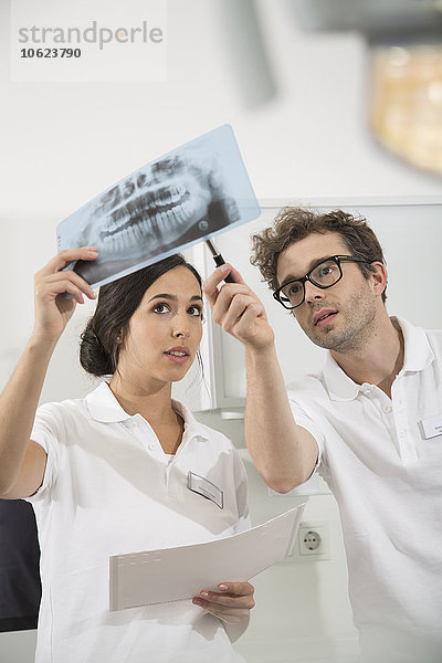 Zwei Zahnärzte in der Zahnarztpraxis diskutieren Röntgenbild